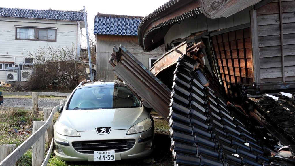 能登半島地震 玄関の軒先の家屋の直撃を受けた車
